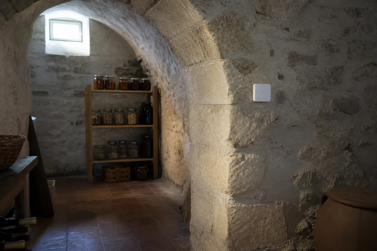 Capteur d’humidité blanc fixé au mur de pierre d’une cave voûtée